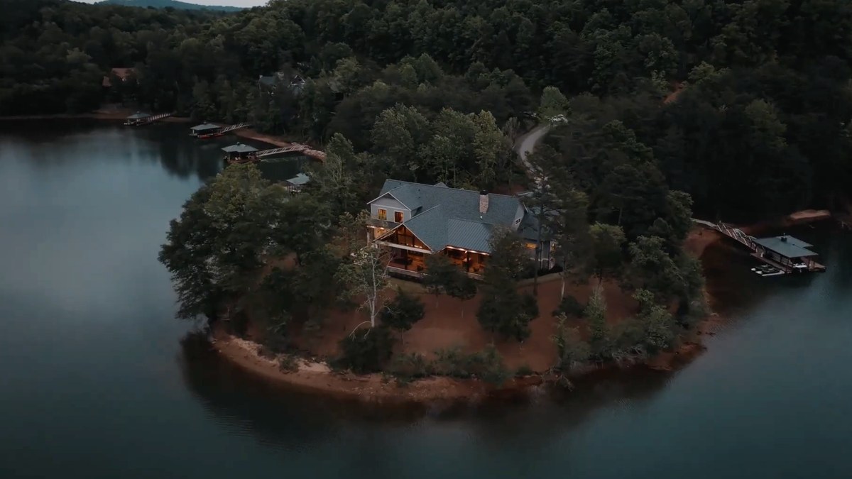 A newly built house on its own wooded peninsula on Lake Keowee at dusk