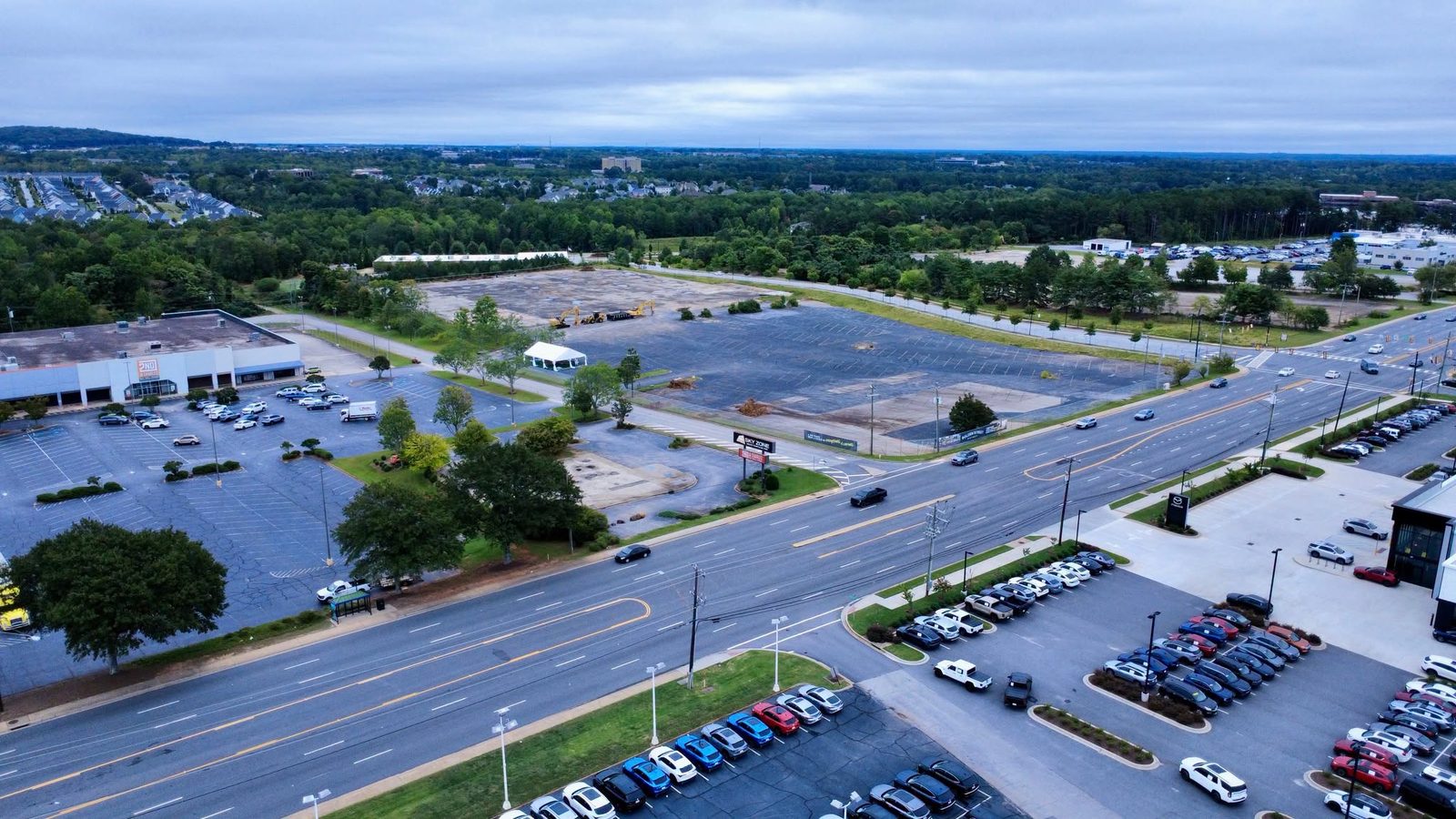 Aerial view of the former Sam's Club lot on Laurens Road with the groundbreaking tent at its center