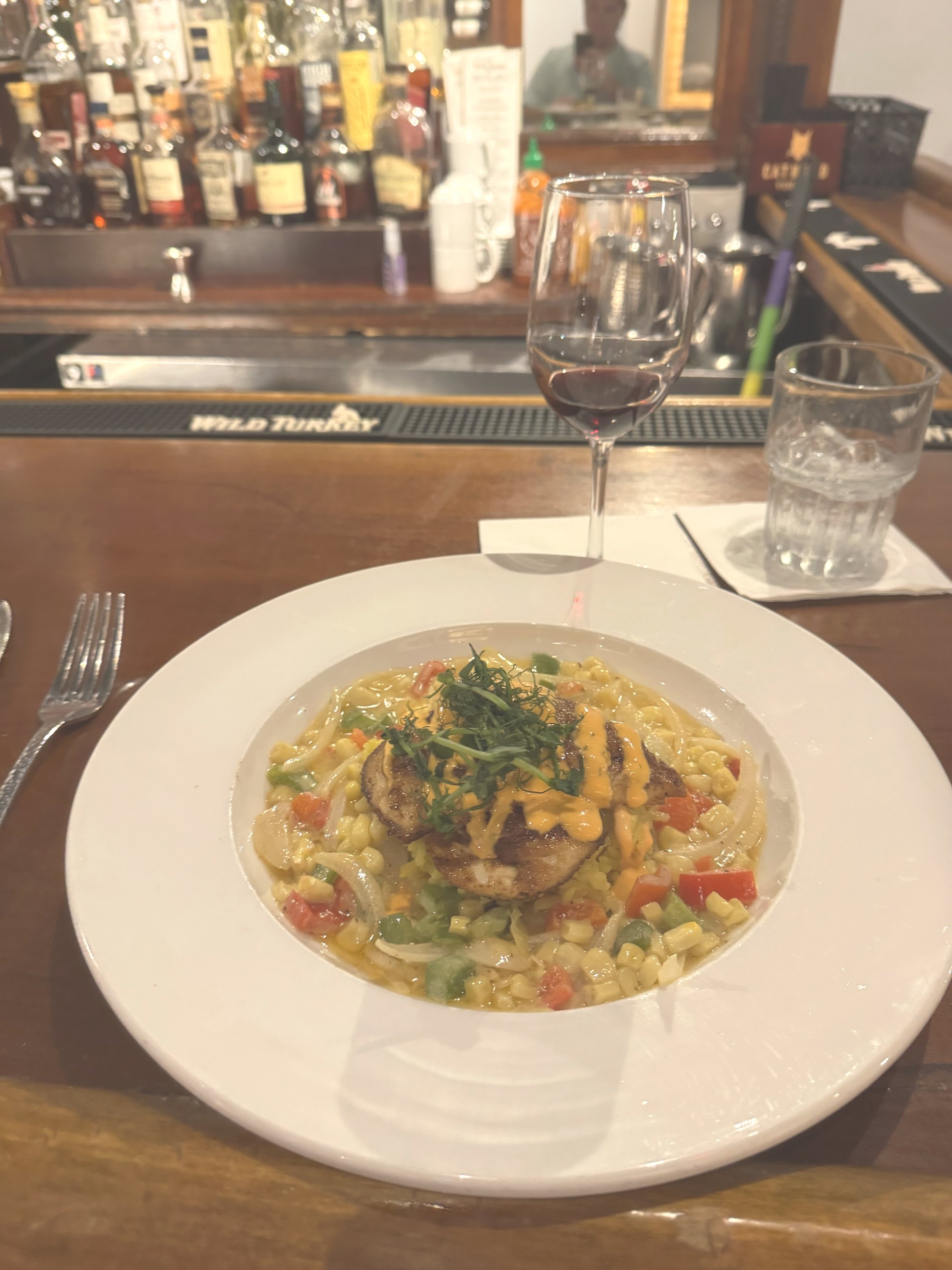 Skillet chicken cutlets with maque choux and yellow rice pilaf at the bar at 82 Queen in Charleston