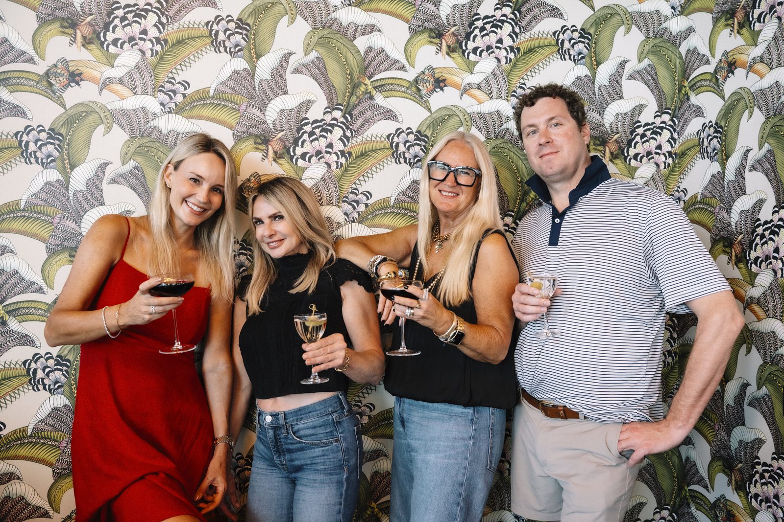 Damian Hall with Kathy Besse and Denise Piper of IndigoOak Christie's International Real Estate against the palm print wallpaper at Lou Lou's Tavern on the Tracks in Charleston