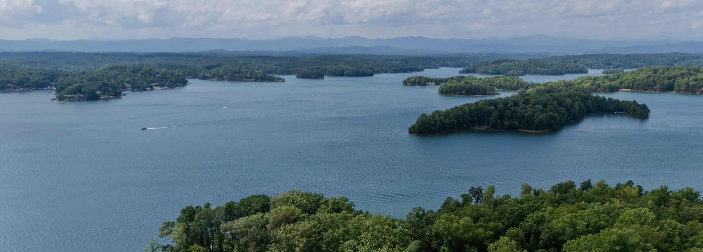 Drone photograph above the point at 233 Sandy Hollow Court, looking down Lake Keowee toward the Blue Ridge
