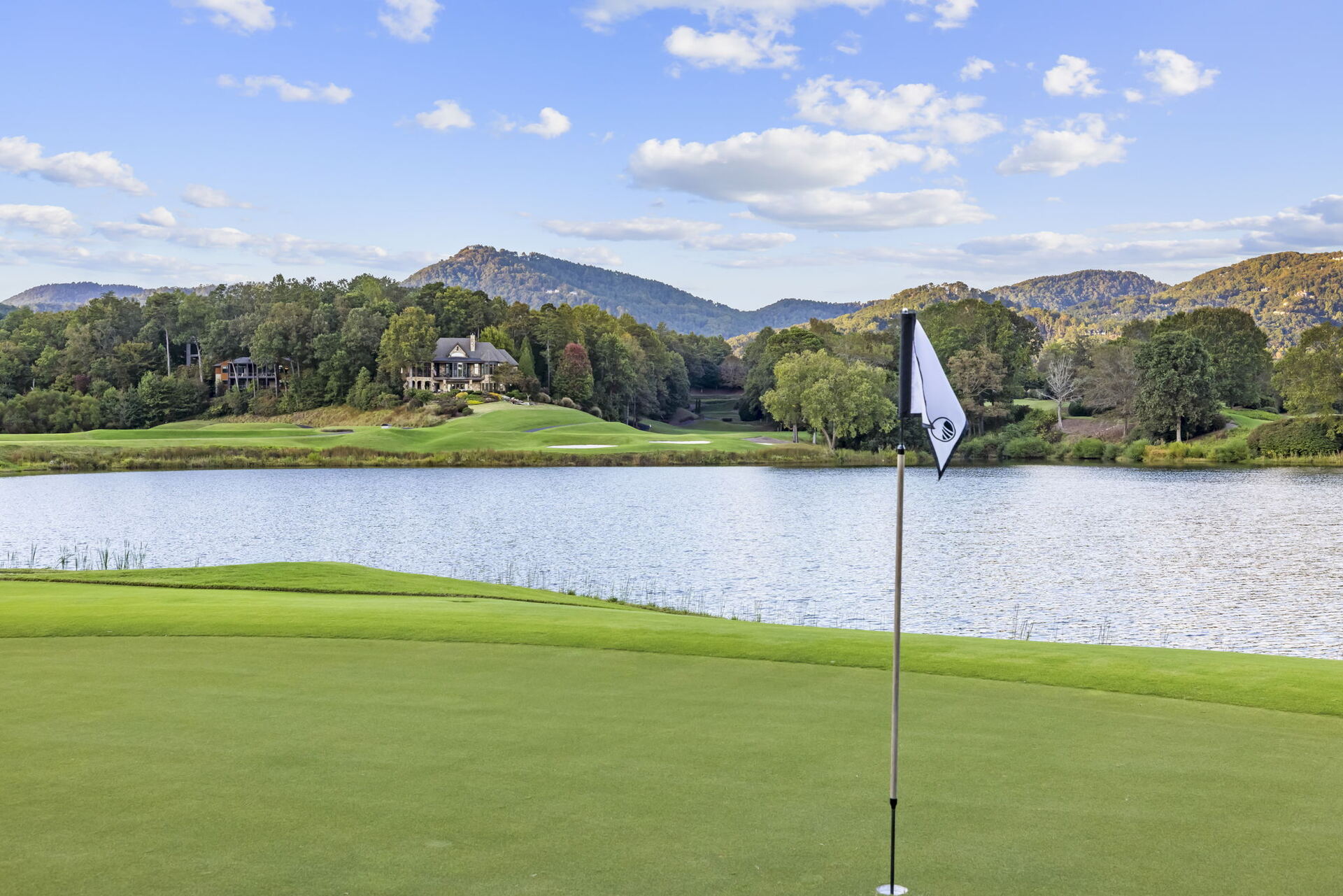 A green and pin at Cliffs Valley with the lake and the Blue Ridge behind