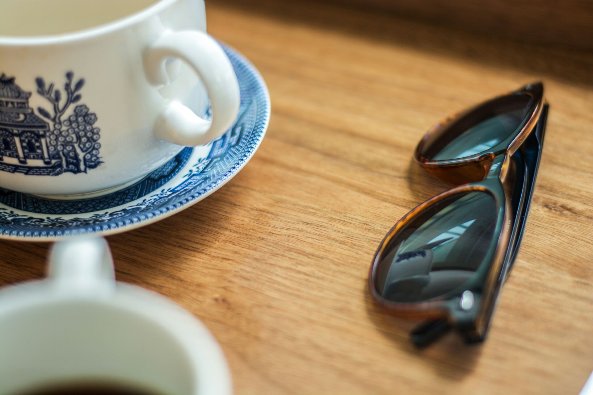 A cup of coffee and a pair of glasses on a table