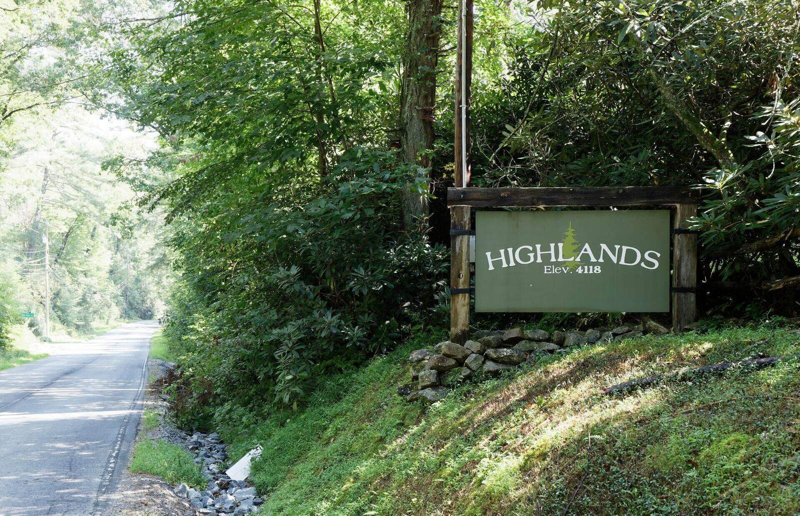 The Highlands town sign on the roadside beneath the trees