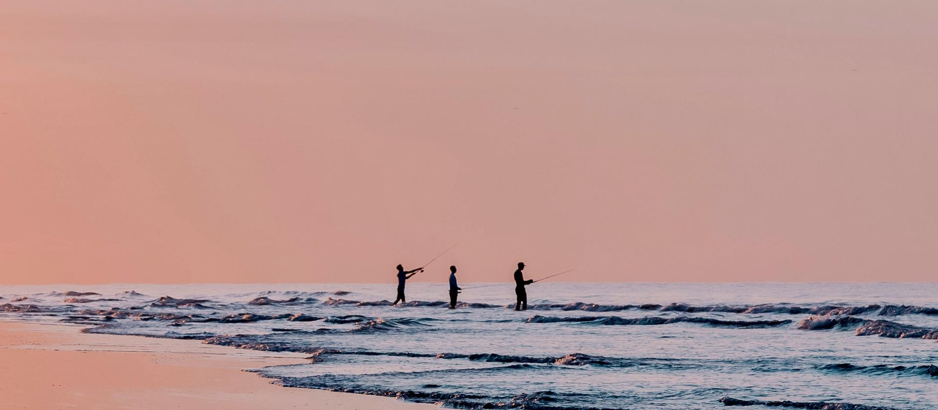 Three surf fishermen at sunrise on Sullivan's Island beach
